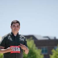 A participant giving peace signs as he races.